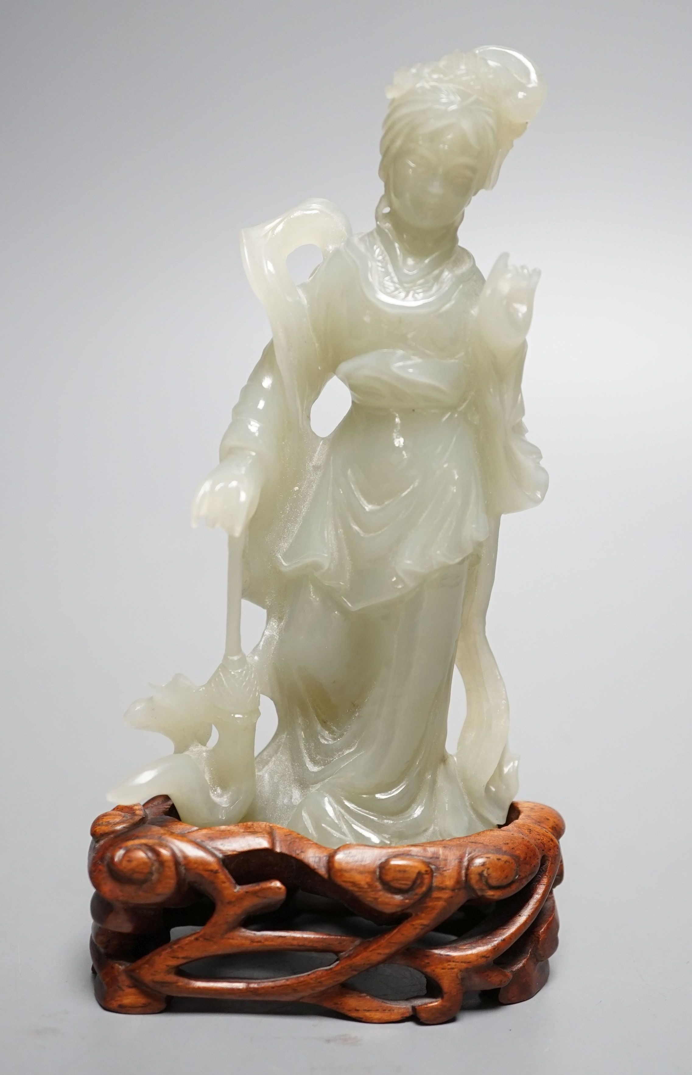 A Chinese celadon jade figure of a lady wood stand, 13 cms high.